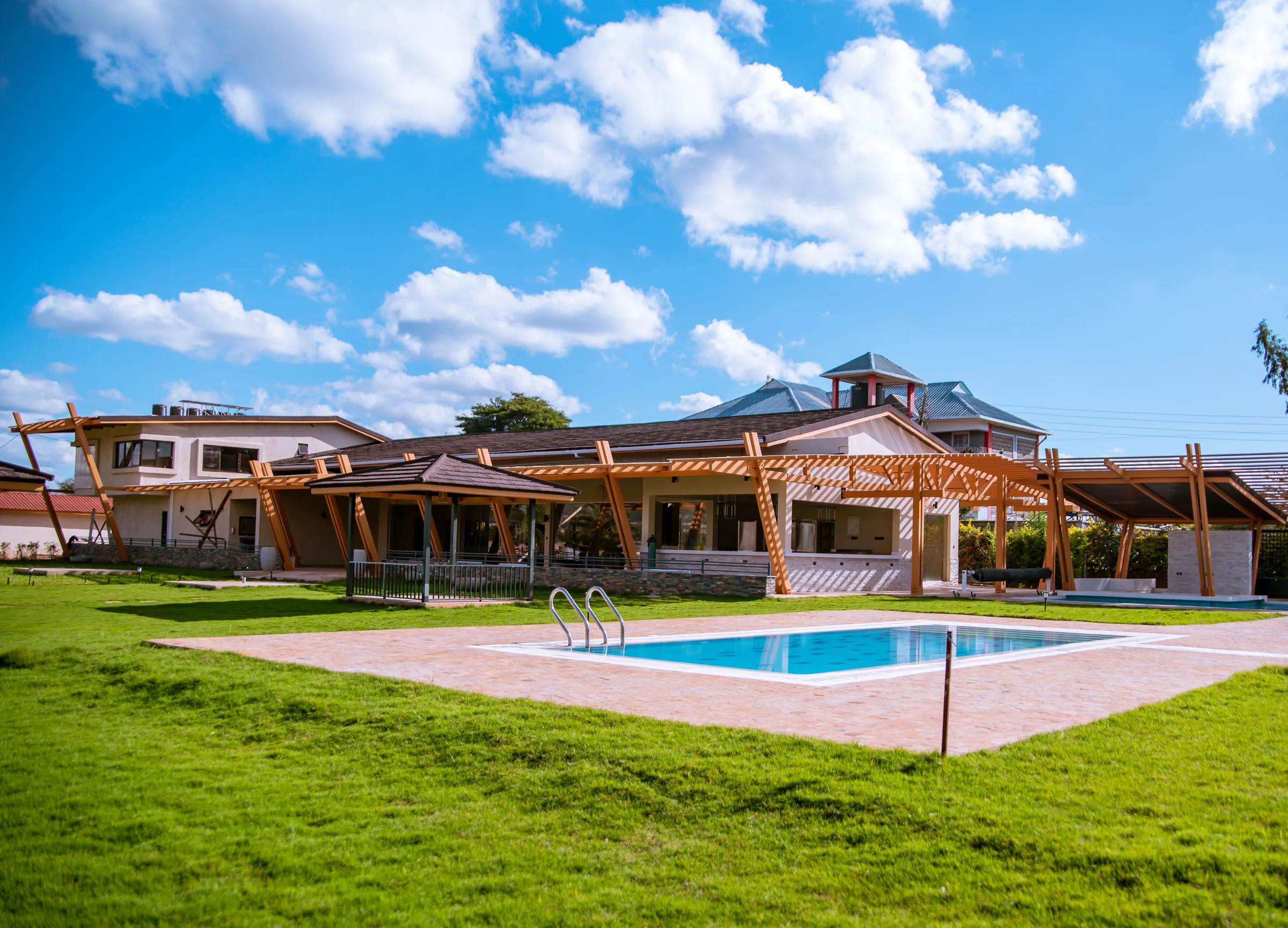 Timber pergola beams framing the resort's main pool at Acacia Woods